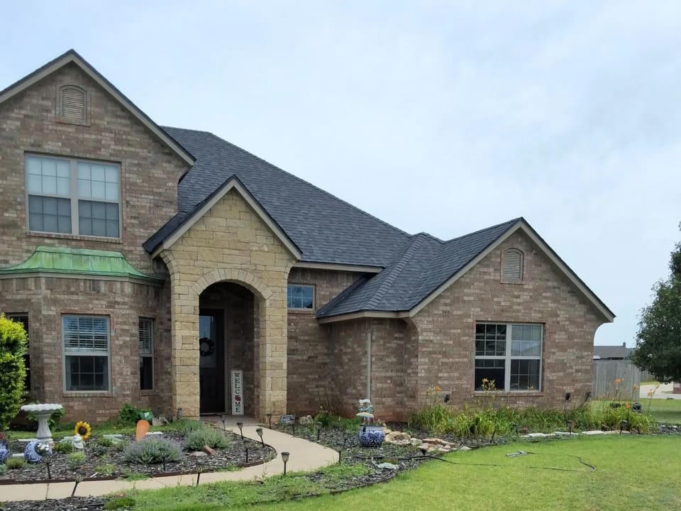 Two-story brick and stone Yukon home with a freshly painted exterior